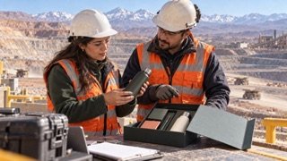 Profesionales de faena revisan un kit de terreno en una zona segura de una mina.